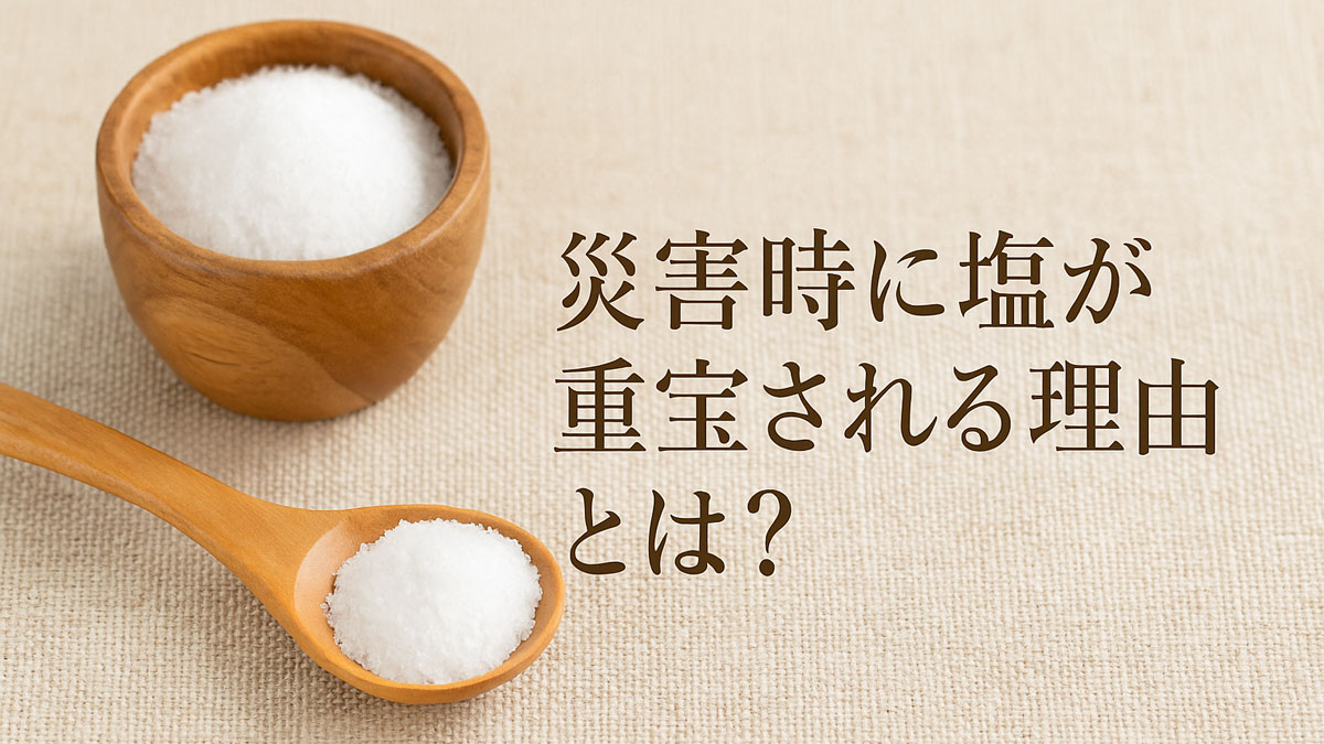 災害時に塩が重宝される理由を表現した画像。白い塩が入った木製の器とスプーンがナチュラルな布の上に置かれ、右側に「災害時に塩が重宝される理由とは？」という日本語テキストが配置されている。温かくやさしい雰囲気の画像。